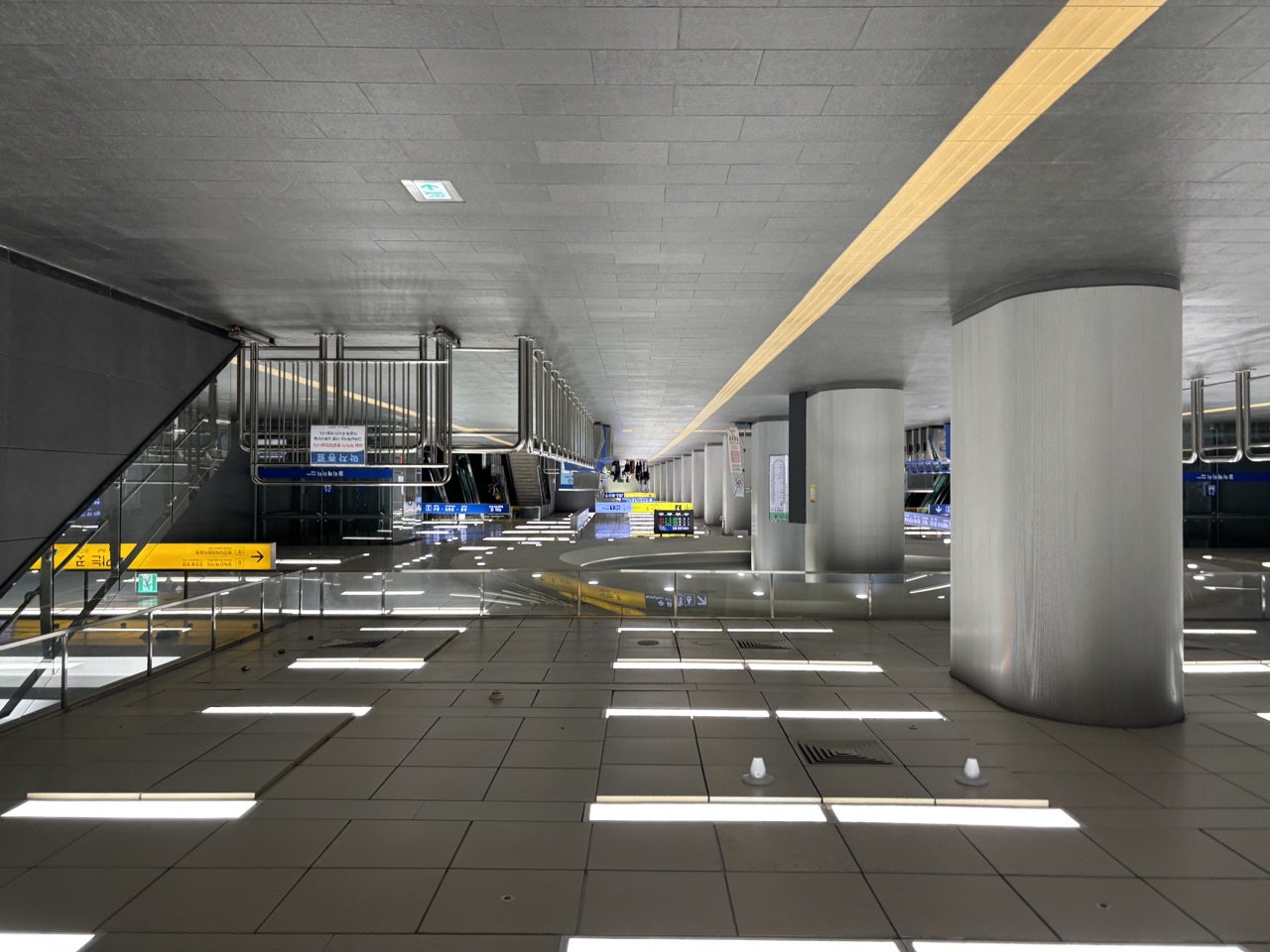 Hongik University Station concourse with overhead wayfinding signs