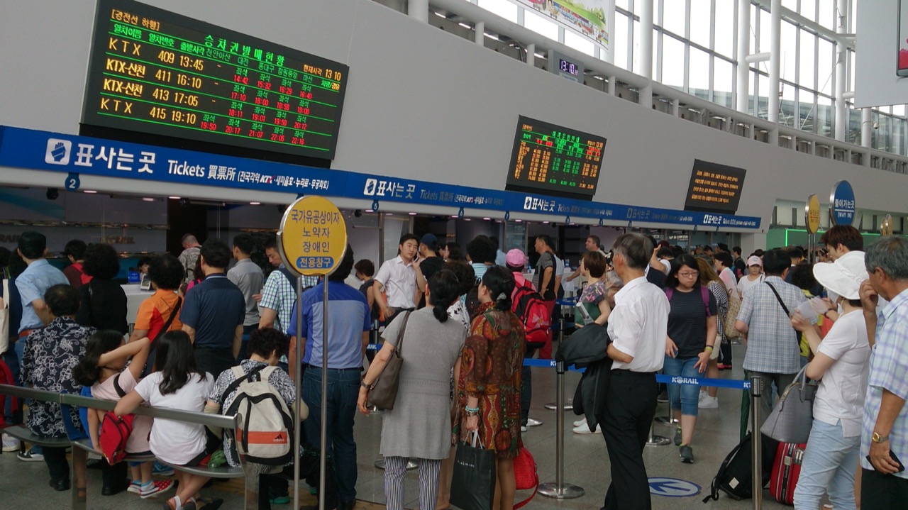 Staffed ticket counters and waiting passengers inside Seoul Station