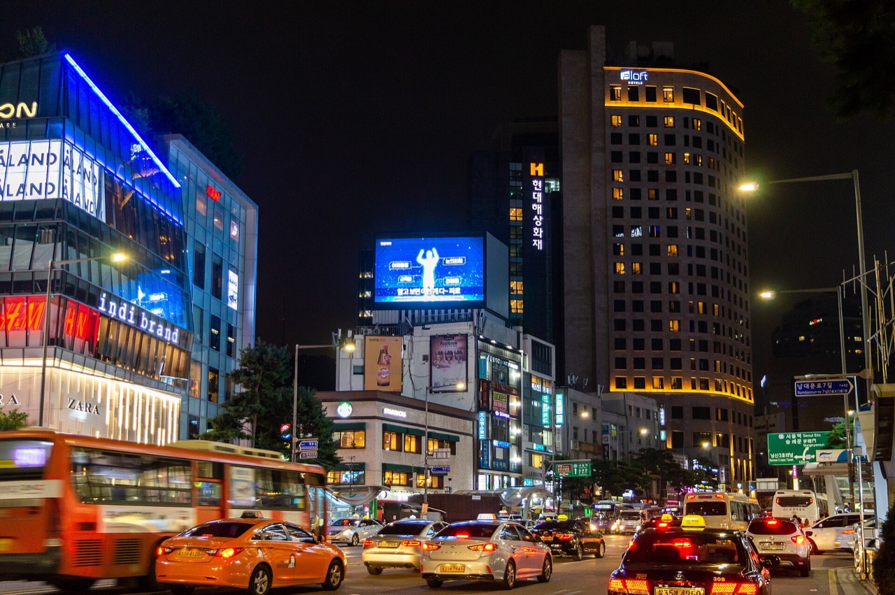 Namdaemun-ro beside Myeongdong illuminated after dark with buses and city traffic